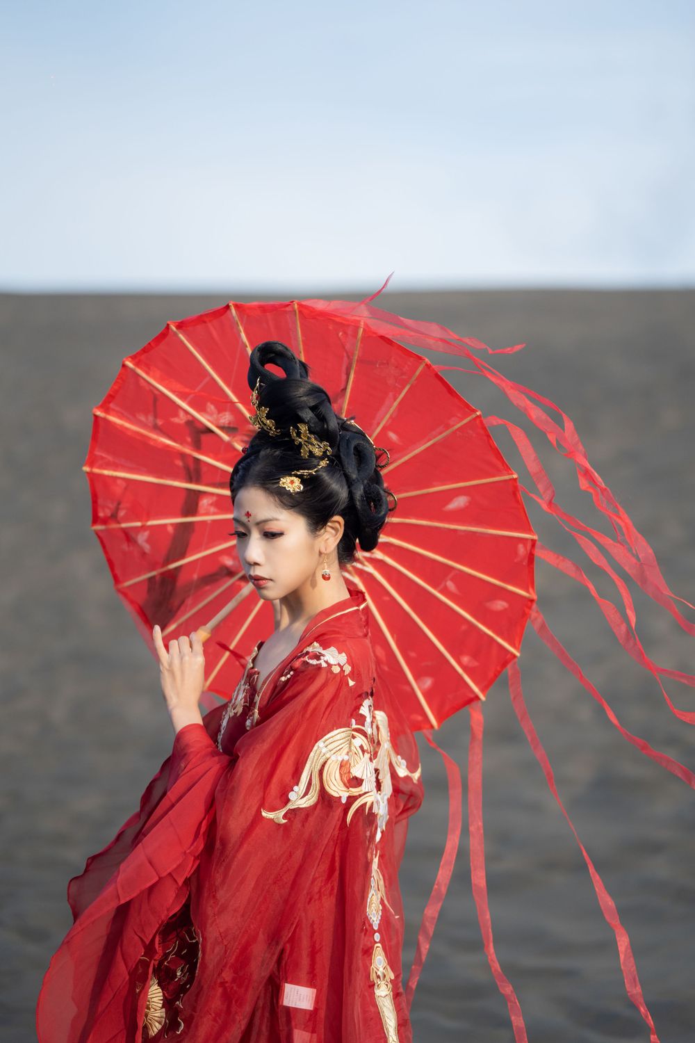 Cinematic solo portrait in flowing red Hanfu at Lake Wainamu sand dunes, evoking a fateful Desert Princess vibe, by Imagine Image Studio.