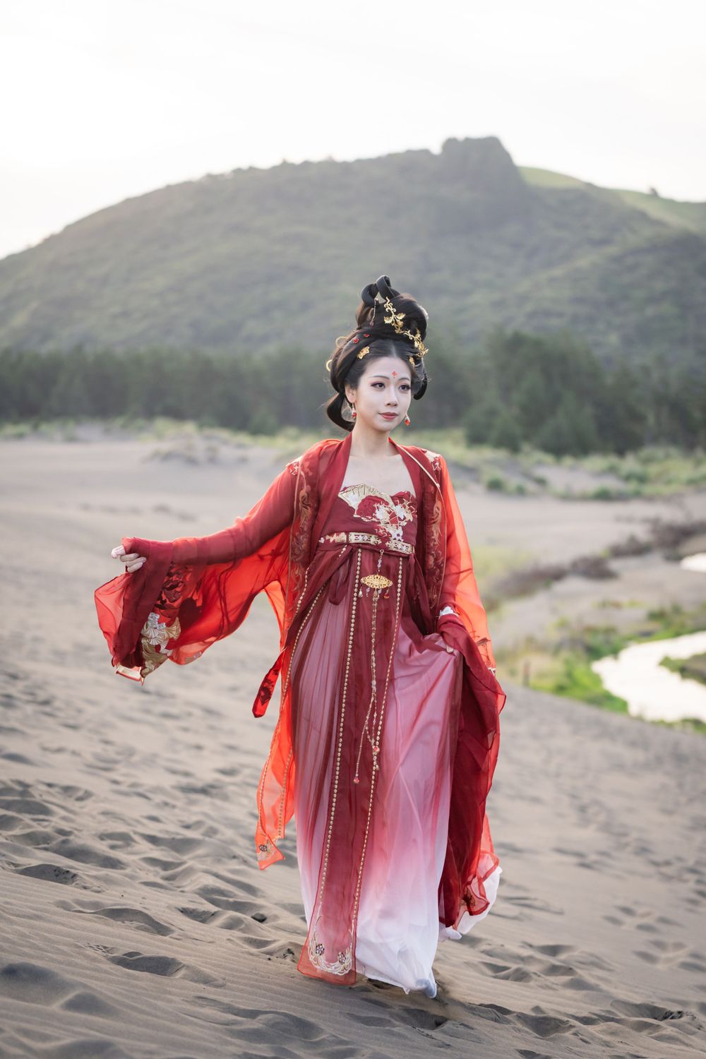 Cinematic solo portrait in flowing red Hanfu at Lake Wainamu sand dunes, evoking a fateful Desert Princess vibe, by Imagine Image Studio.