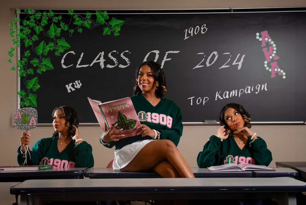 Students pose playfully on desks in front of a chalkboard showing 'Class of 2024' text.
