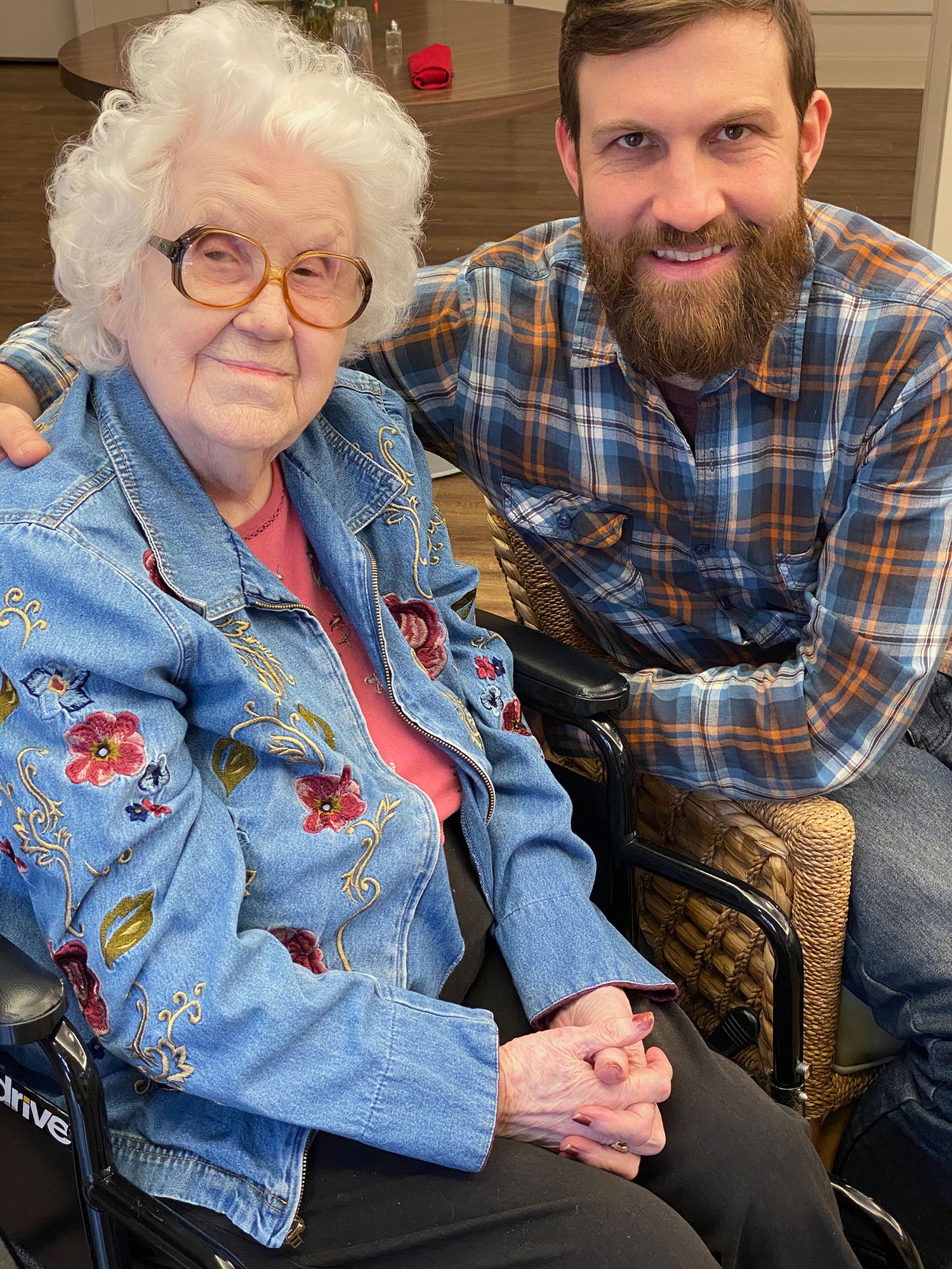 Granny Maxine in a flower embroidered jean jacket sitting with grandson Alex Kent in plaid shirt.