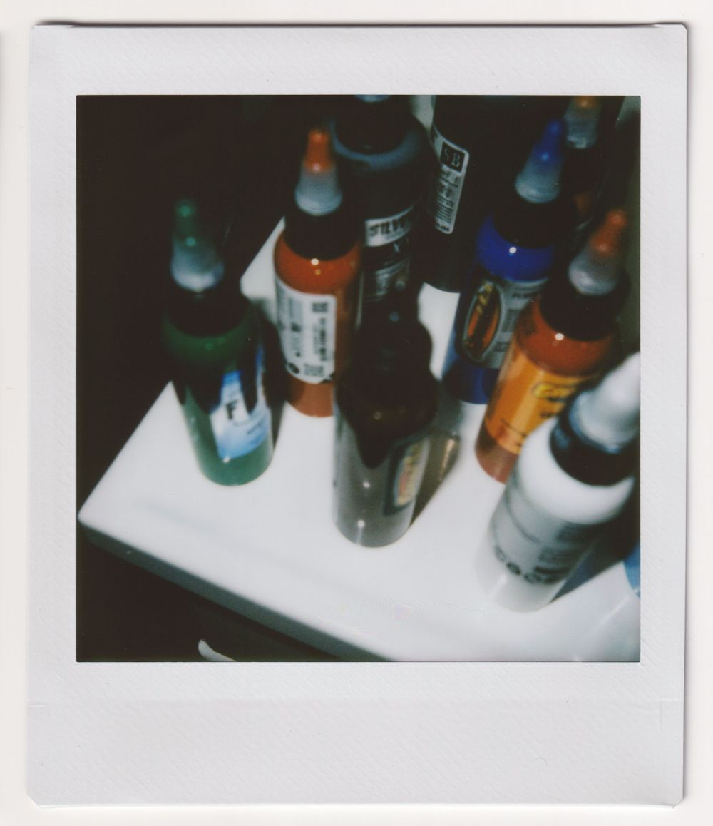 Collection of assorted beverage bottles photographed from above on white surface.
