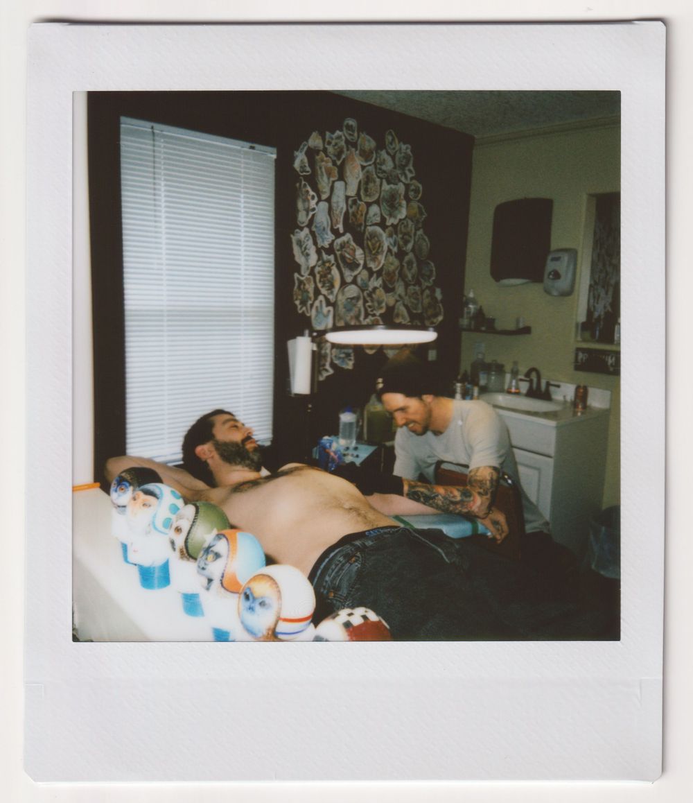 Professional tattoo session in progress with equipment and supplies visible.