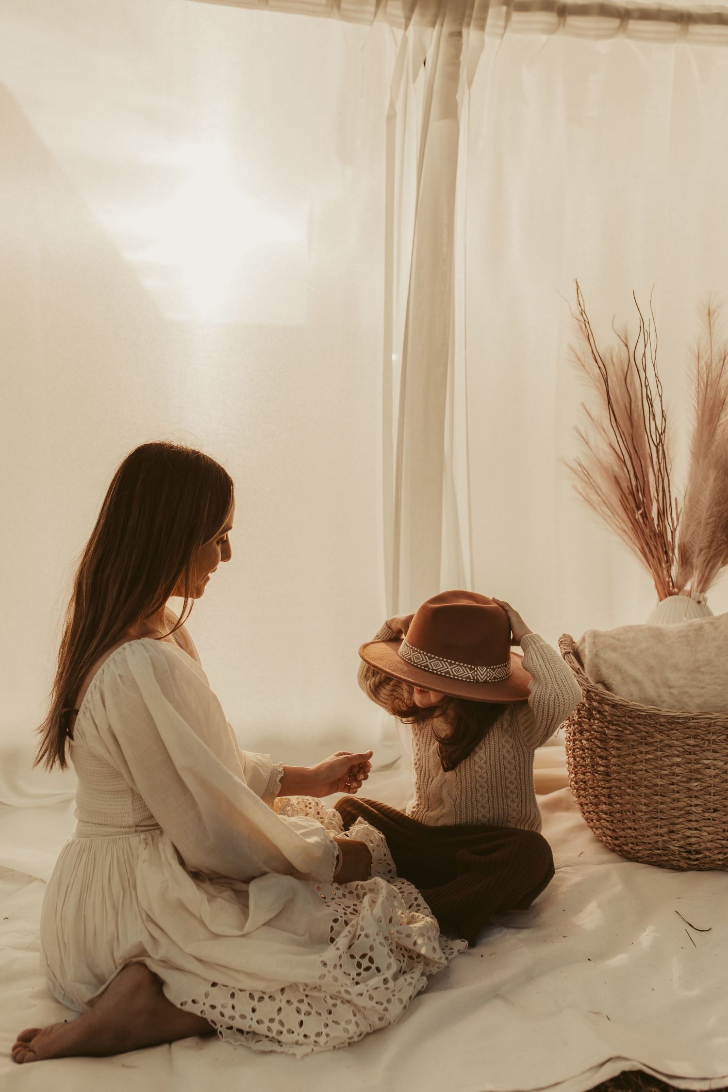 Dreamy indoor portrait with boho styling featuring woven basket and pampas grass decor.