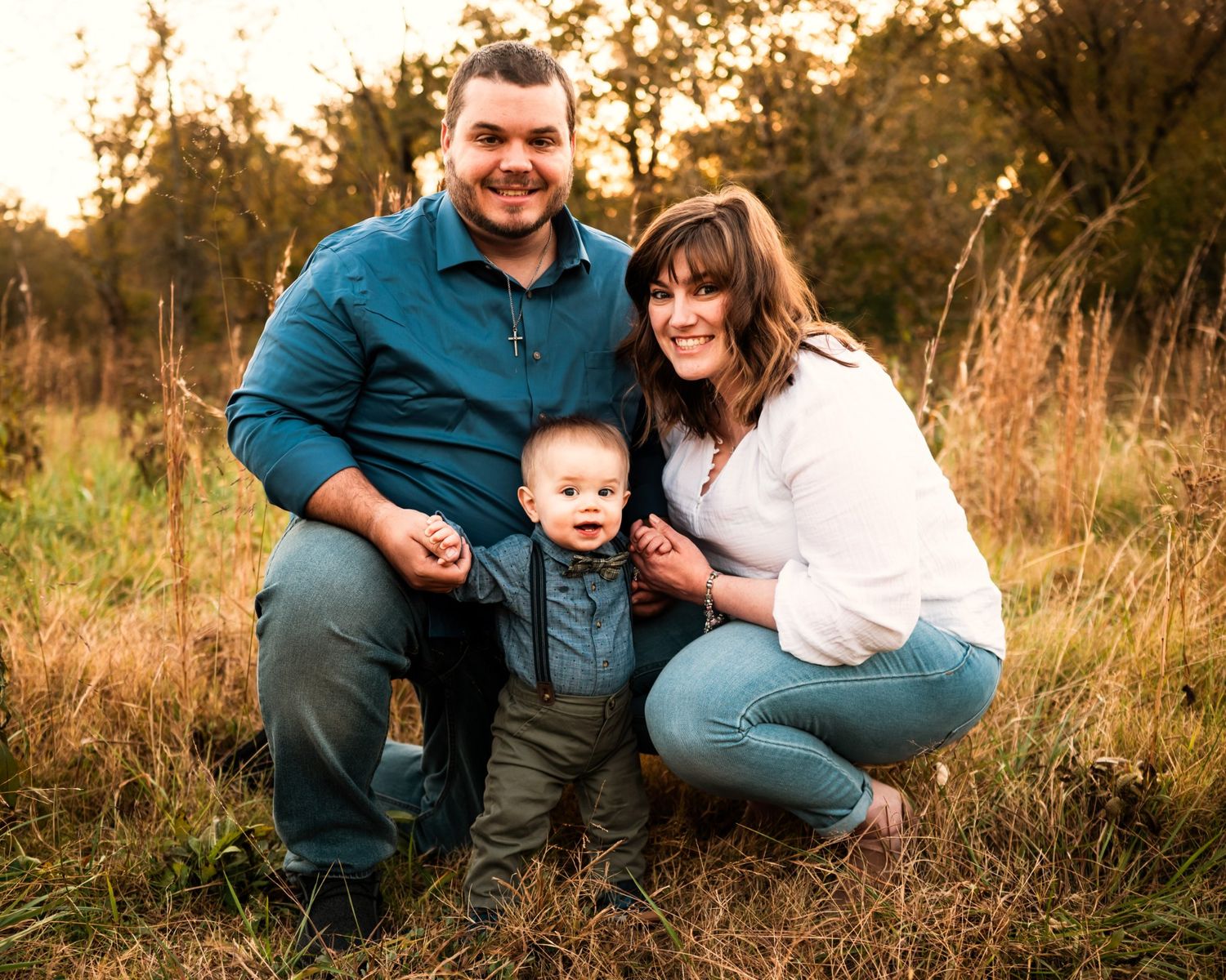 Outdoor family portraits at golden hour in a natural field setting.