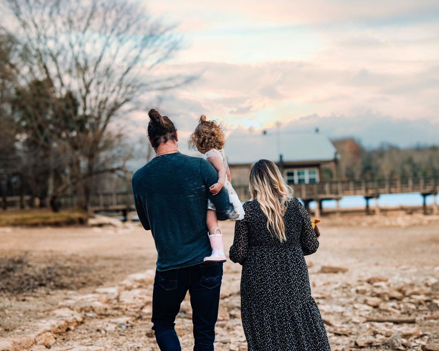 Family walking together along a scenic path during golden hour photography session.