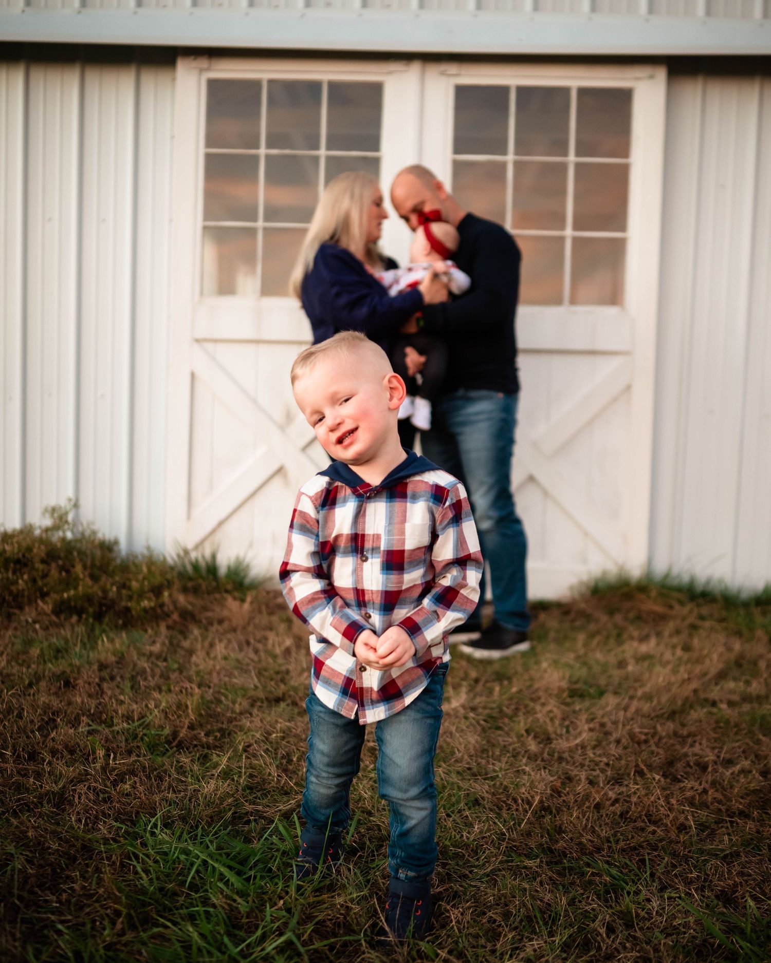 Candid family moments captured in front of a rustic white building.