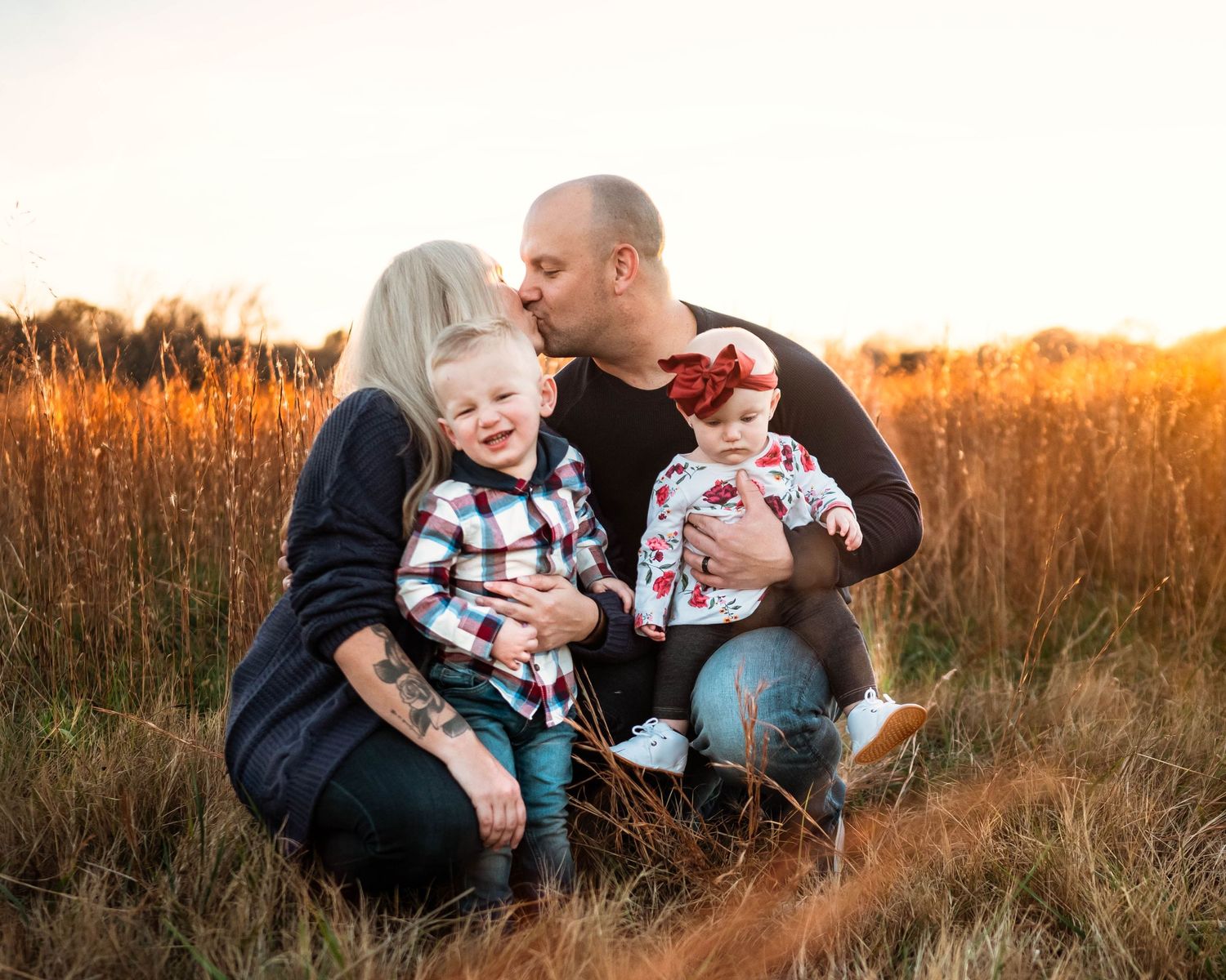 Candid family moments captured in tall grass during golden hour.