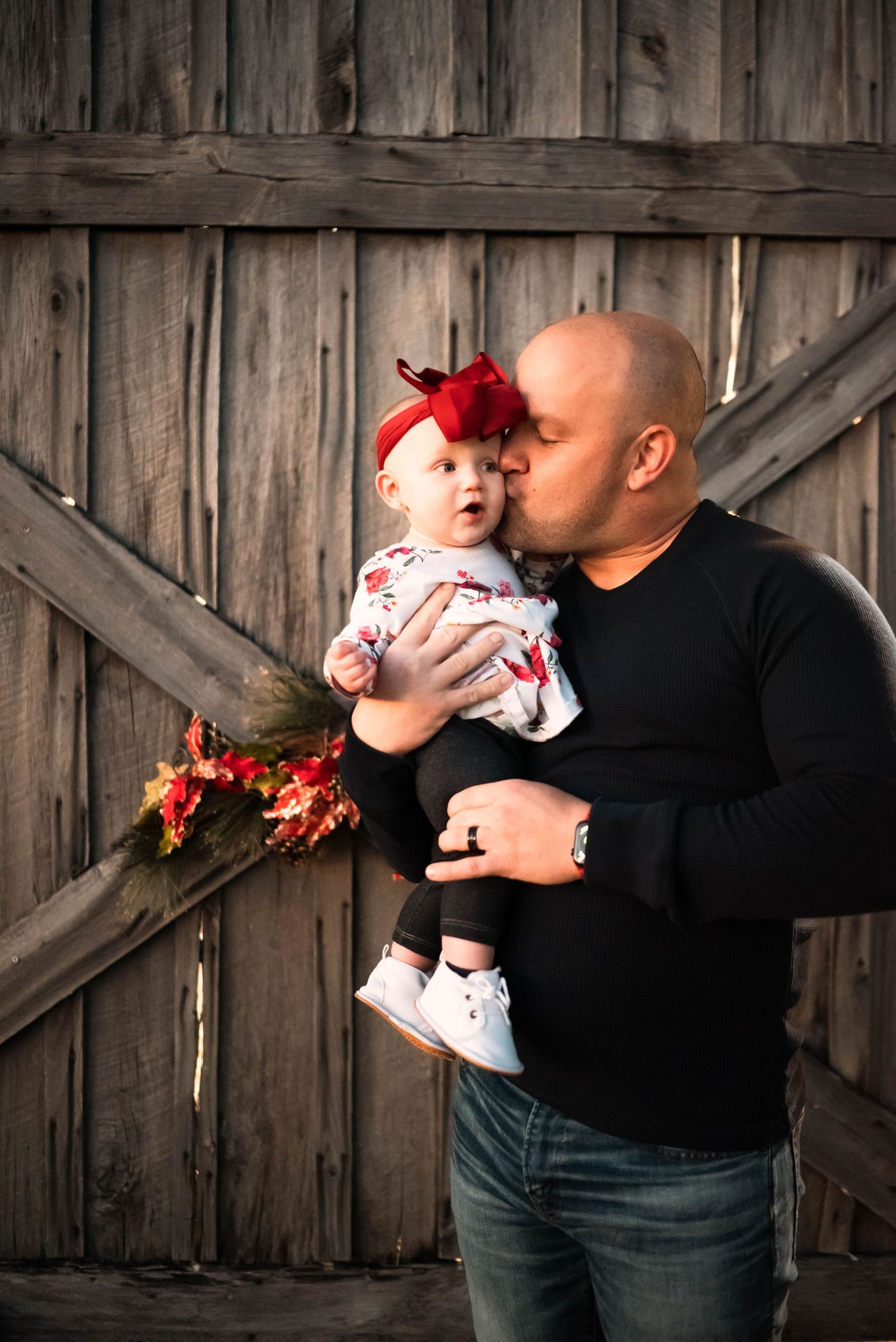 Intimate family moments captured against rustic wooden barn backdrop during sunset.