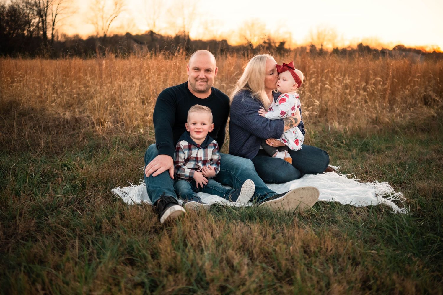 Natural outdoor family portrait session with golden sunset in background.