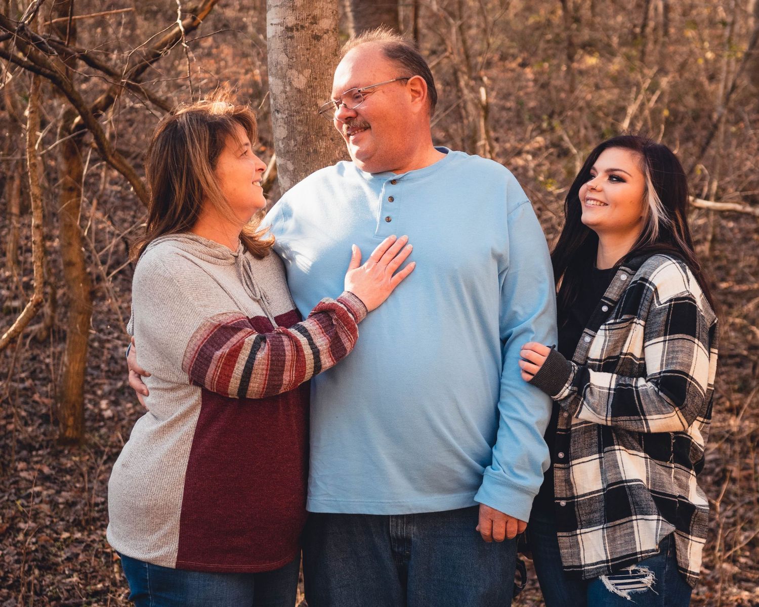Group portrait against natural woodland backdrop wearing coordinated casual outfits.