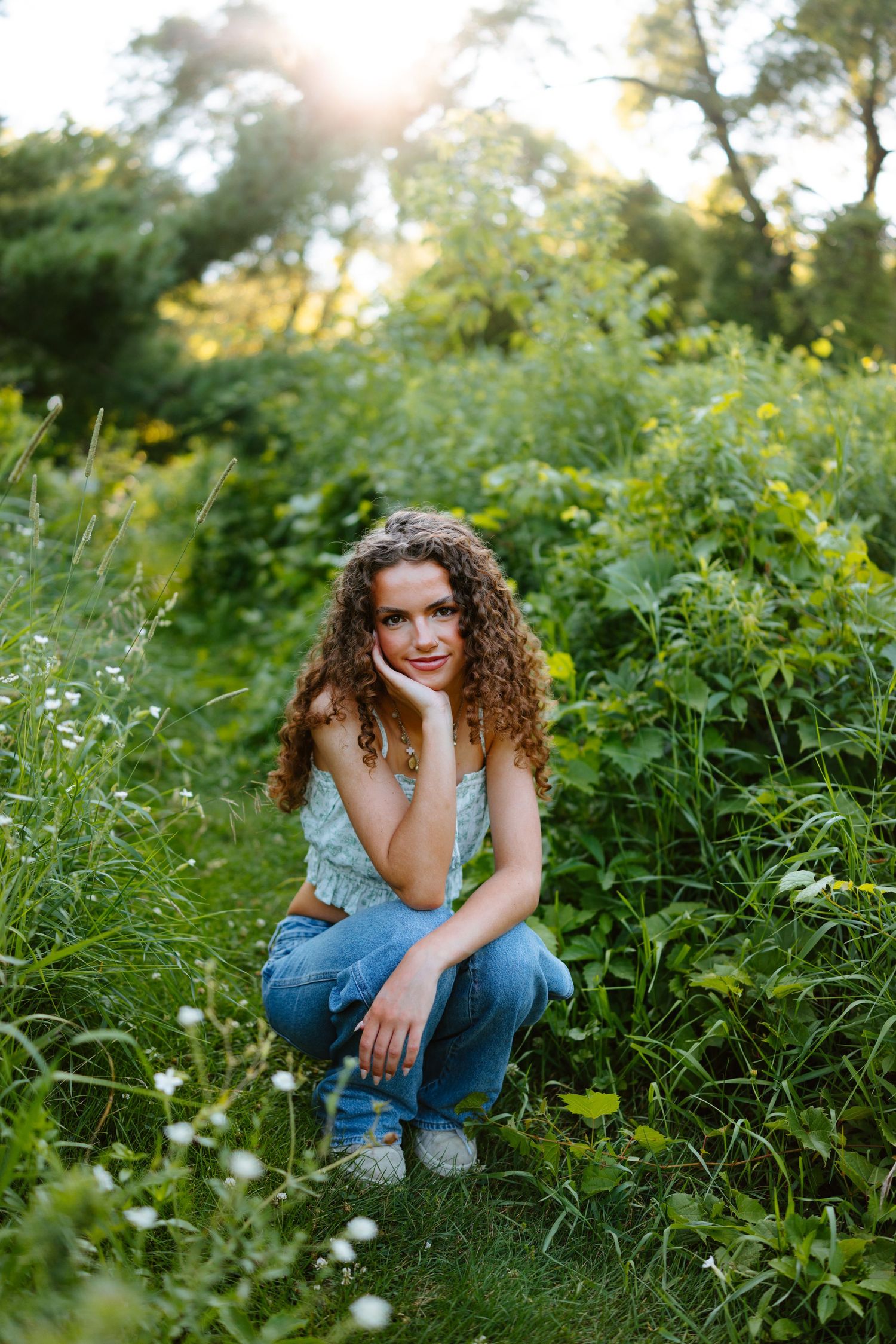 Artistic portrait session by a rocky stream with soft natural lighting and flowing fabric.