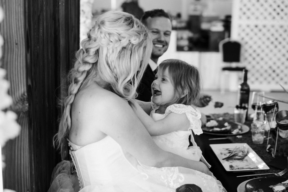 A candid black and white moment shared between wedding attendees during the reception.
