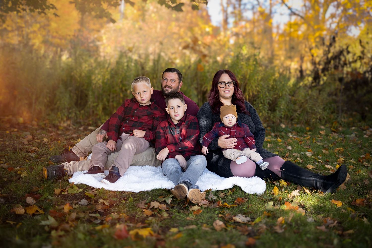 Family photography session on wooden bridge in coordinated blue outfits.