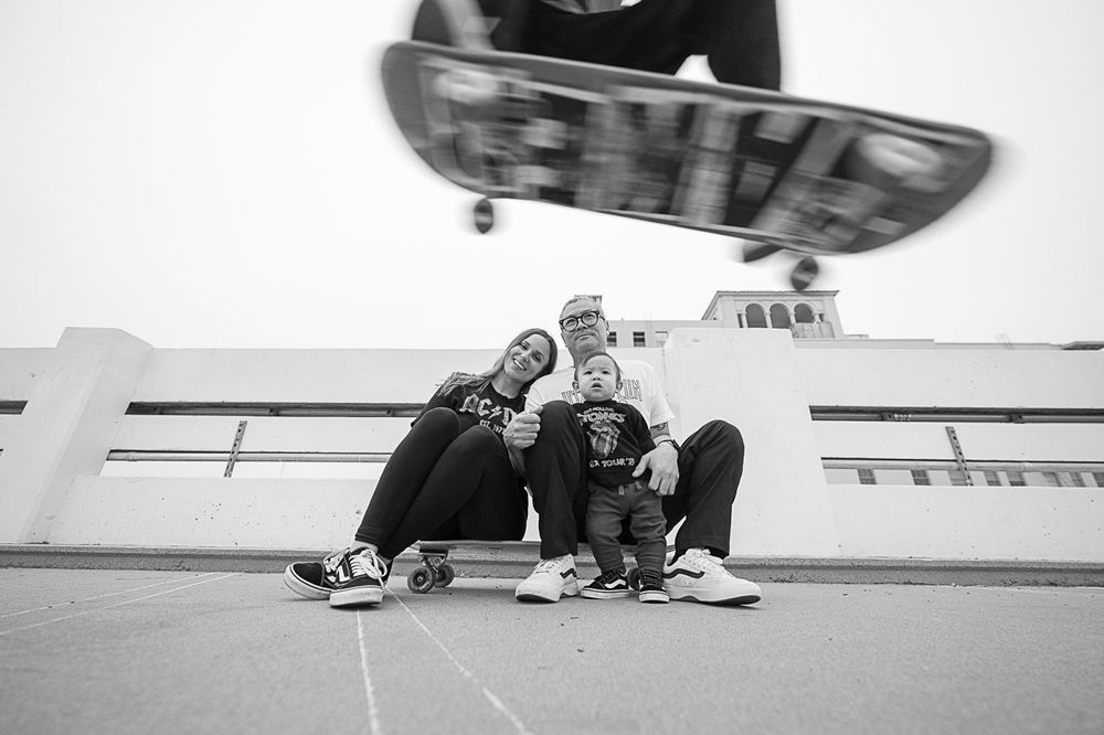 Low-angle action shot of skateboarders performing tricks in black and white.