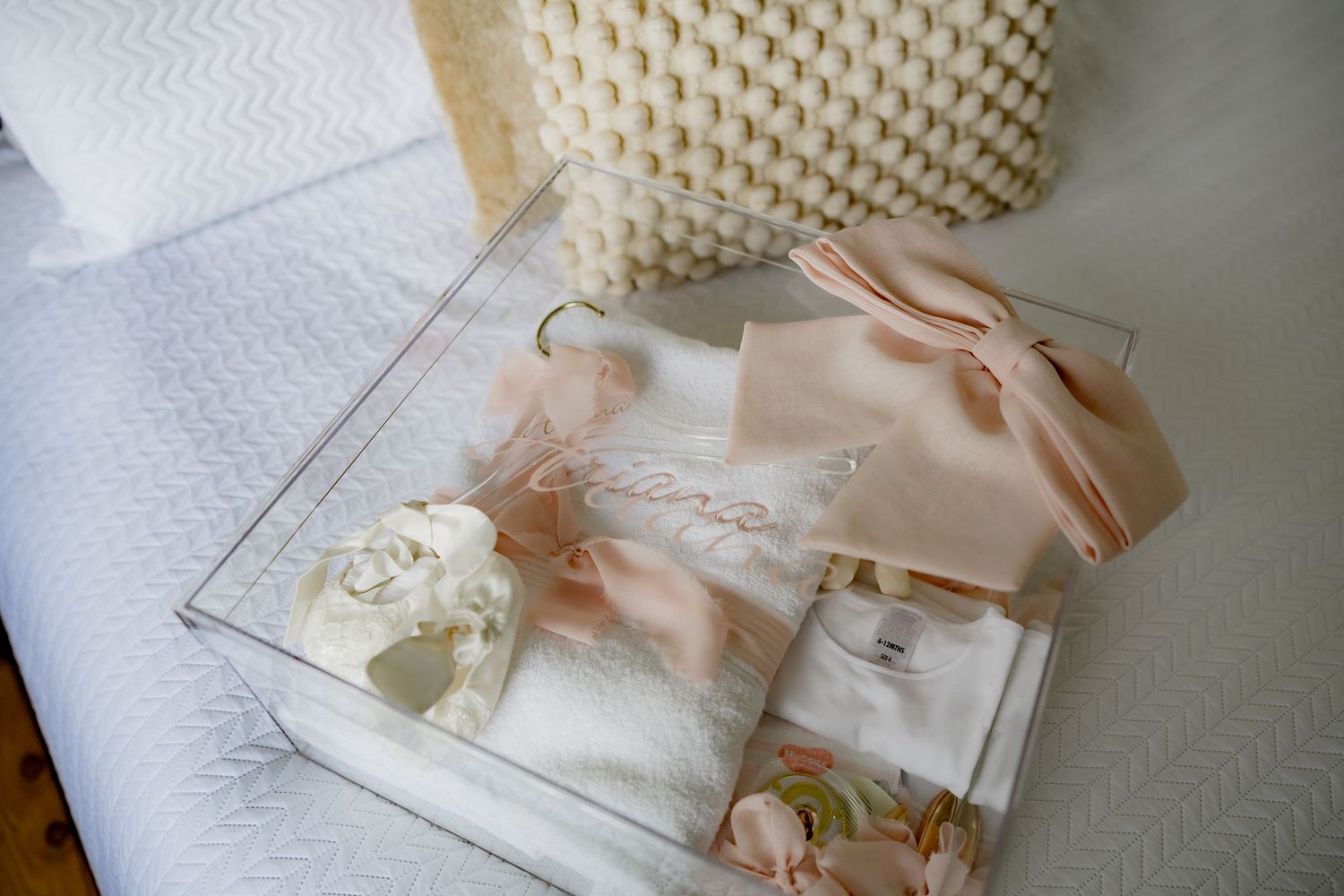 Delicate peach and white baptismal accessories arranged in clear display box.