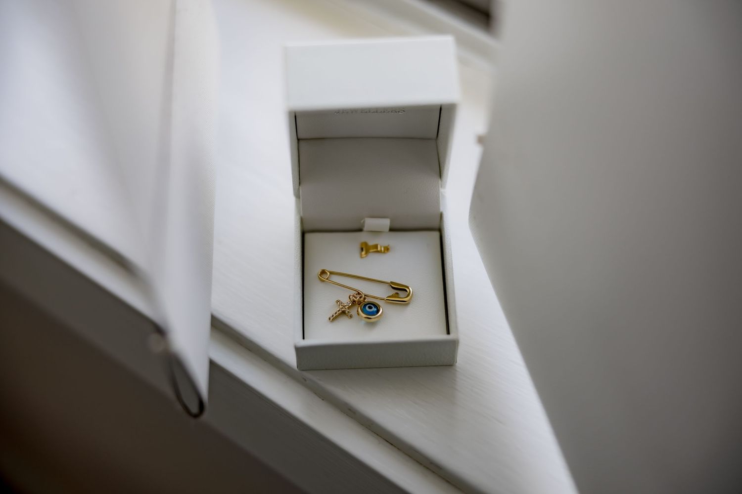 Gold ring displayed in small gray jewelry box.