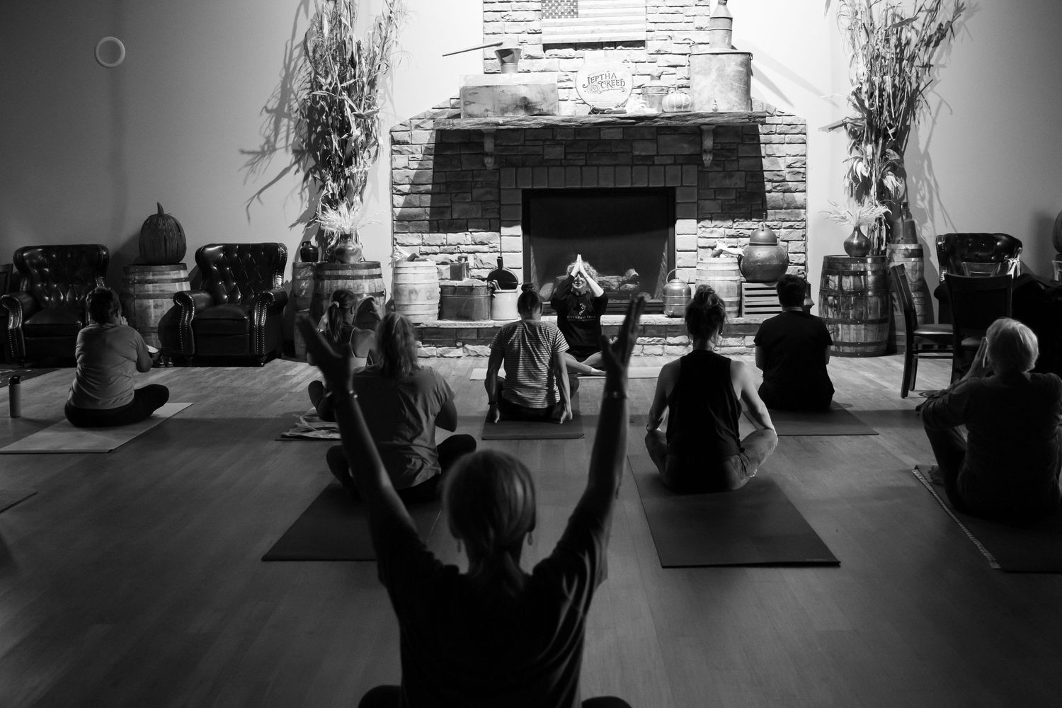 Yoga students in front of a fireplace doing yoga