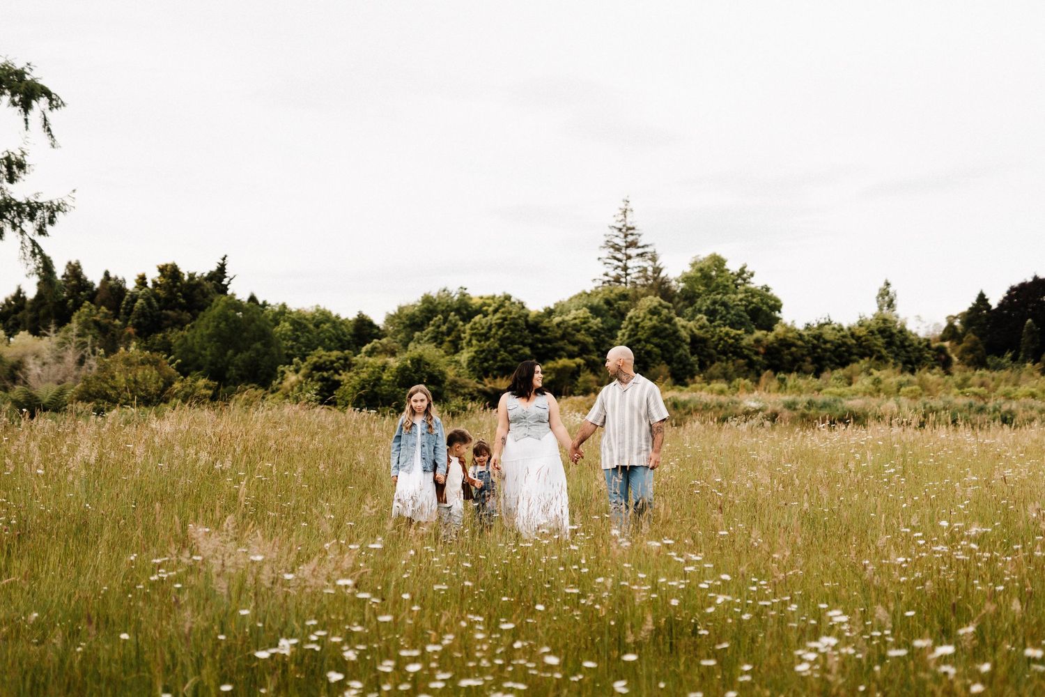 Family walking through a wildflower meadow on a sunny summer day.