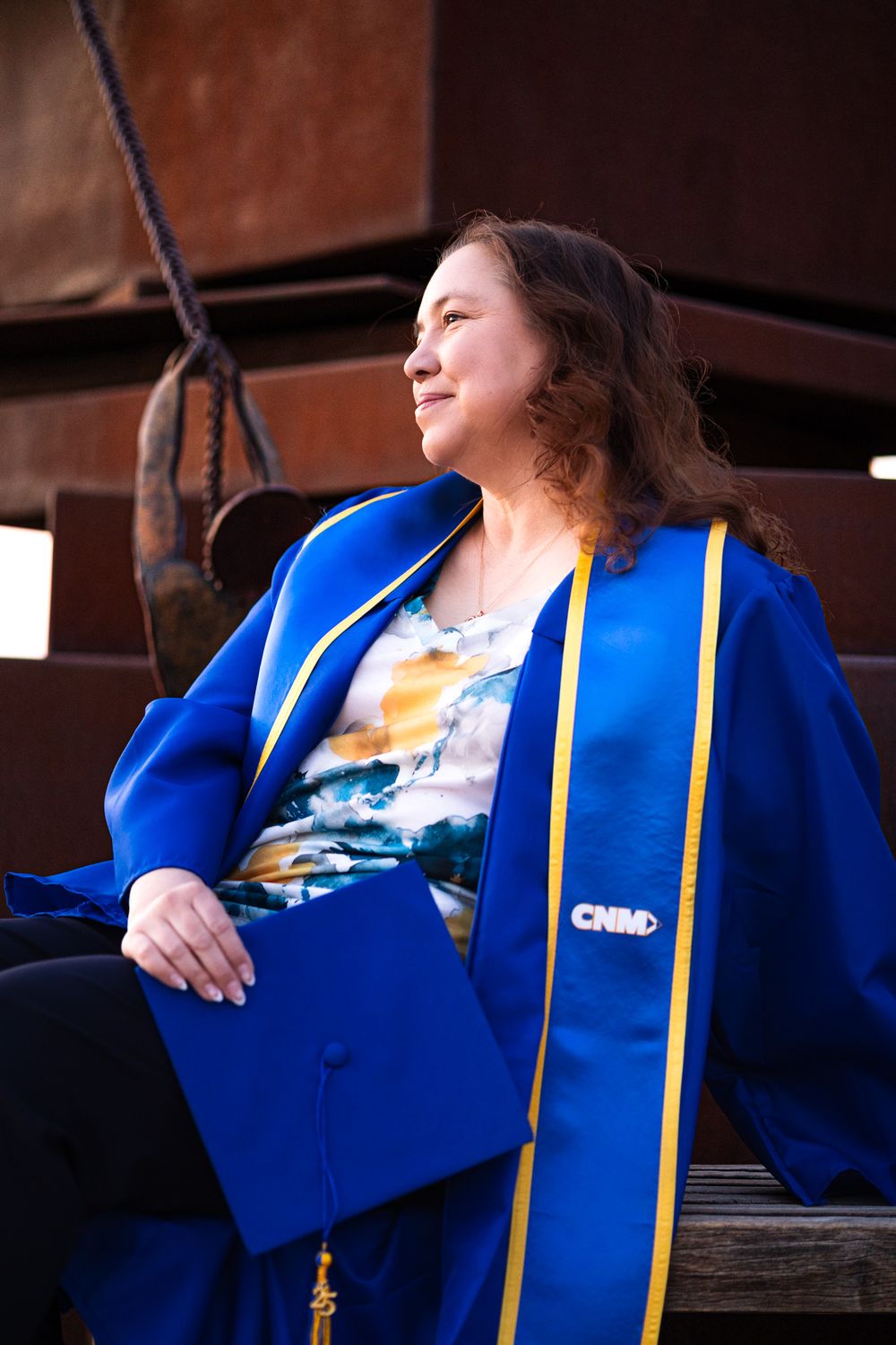Graduation Photo of Oreanna at CNM in ABQ NM looking off in the distance with cap and gown