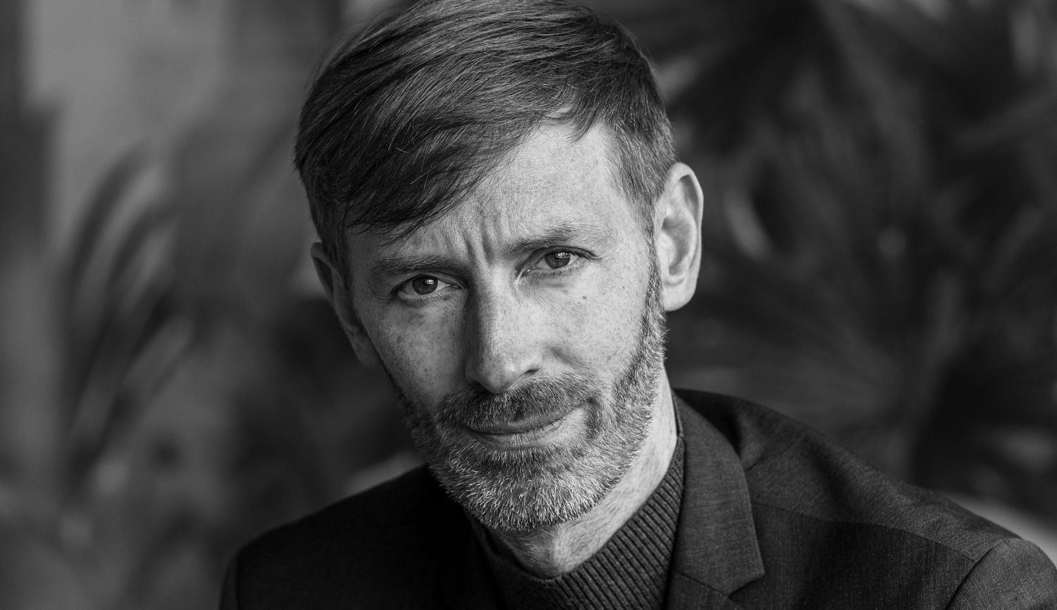 Black and white portrait with dramatic lighting and natural expression.