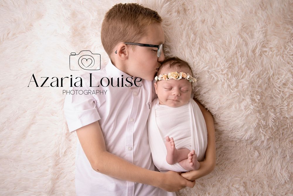 A gentle moment between parent and newborn baby on soft textured beige backdrop with Azaria Louise photography watermark.