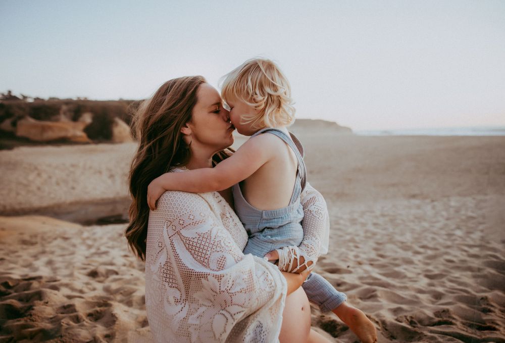 Candid family moments captured against a sandy beach backdrop at sunset.