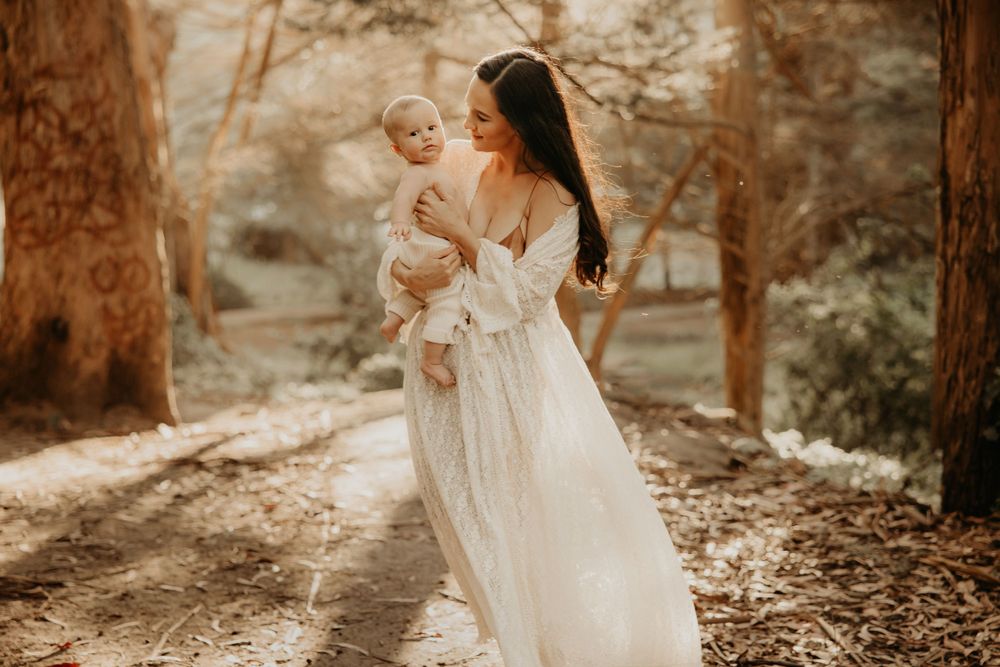 Natural family photography session in a sunlit forest setting.