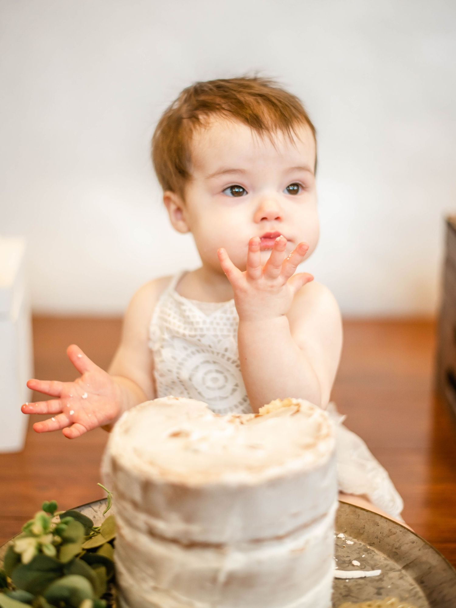 White birthday cake with frosting smears during a festive first birthday celebration.
