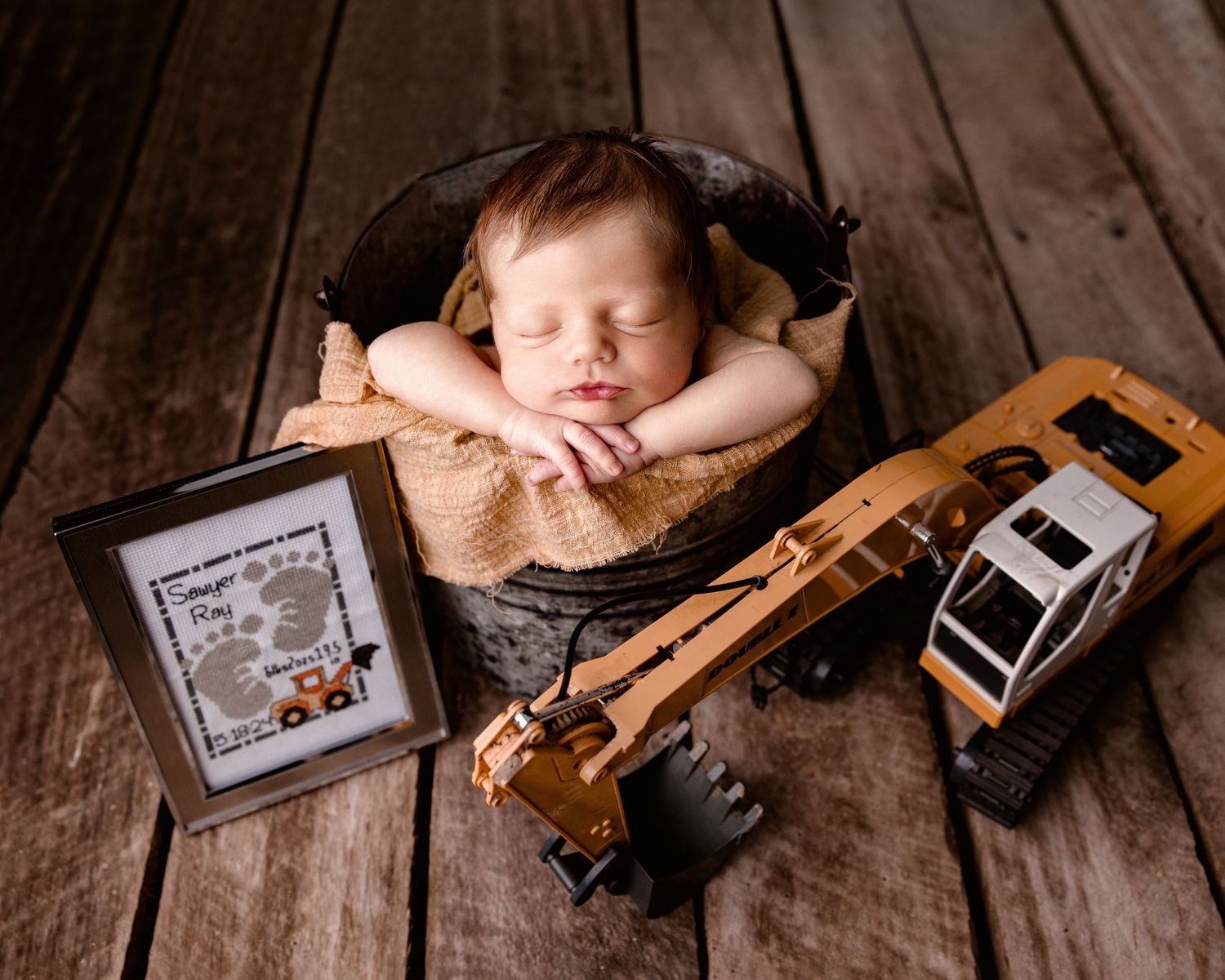 Sleeping baby rests peacefully on rustic wooden surface with contstruction equipment.  Middle TN Newborn Photographer.