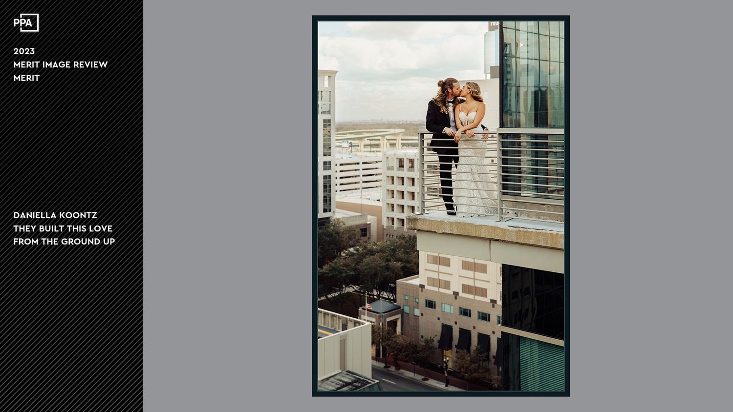 Wedding couple standing on modern balcony overlooking city architecture.