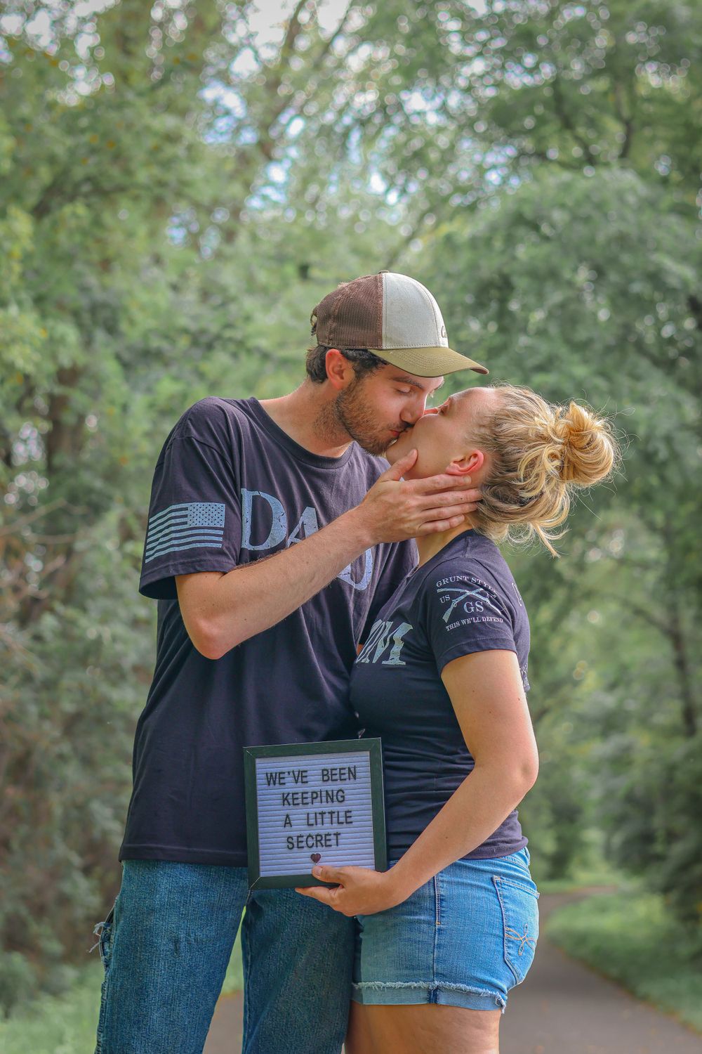 Romantic couple in matching shirts sharing intimate moment outdoors.