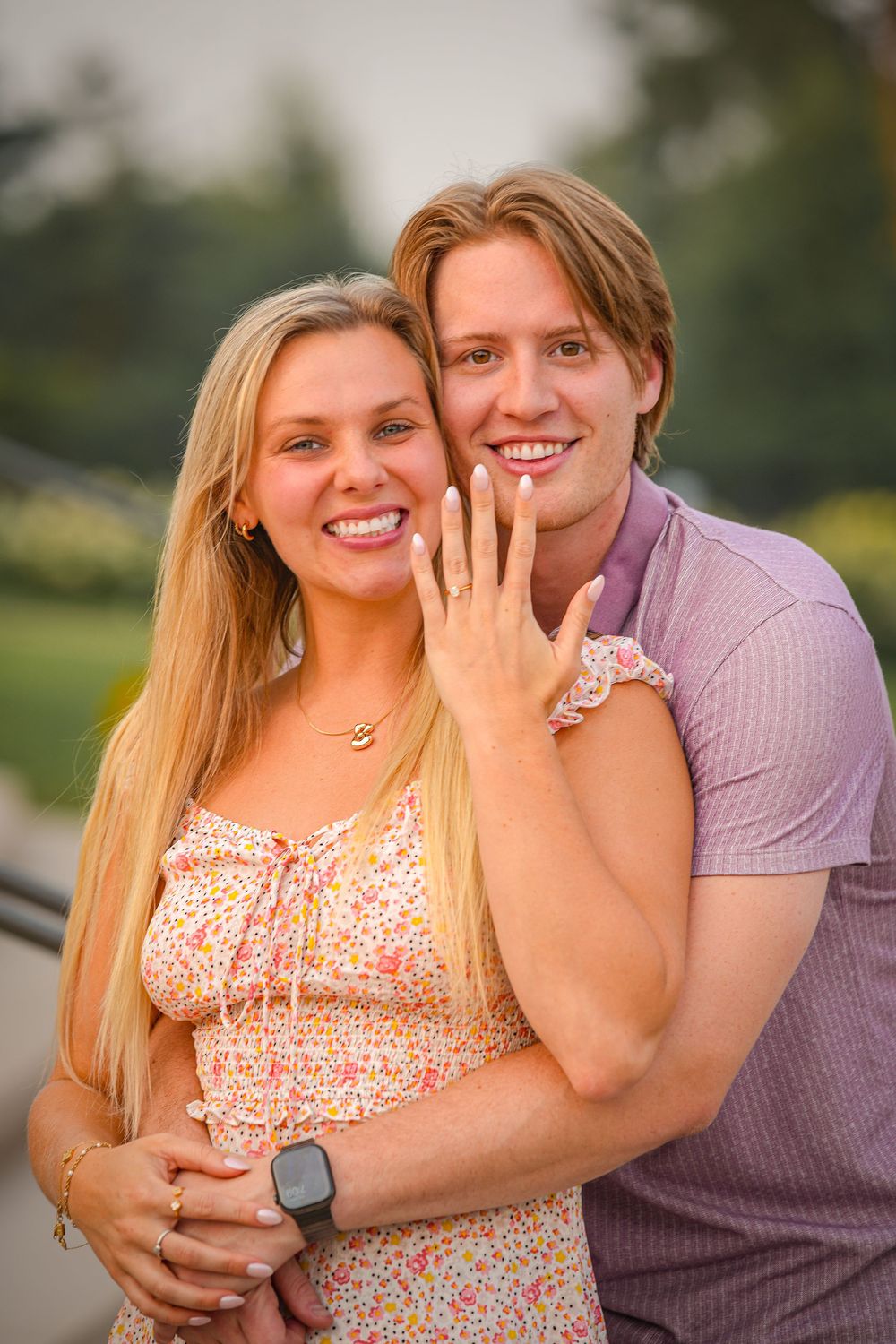 A couple shares joyful moments during an outdoor engagement photoshoot at sunset.