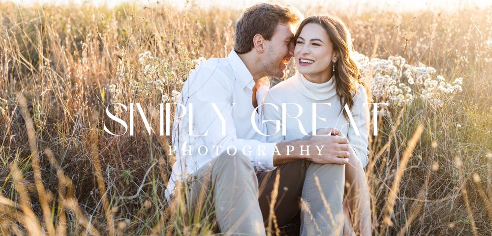 Simply Great Photography banner over a couple sitting in tall grass, cuddling and laughing