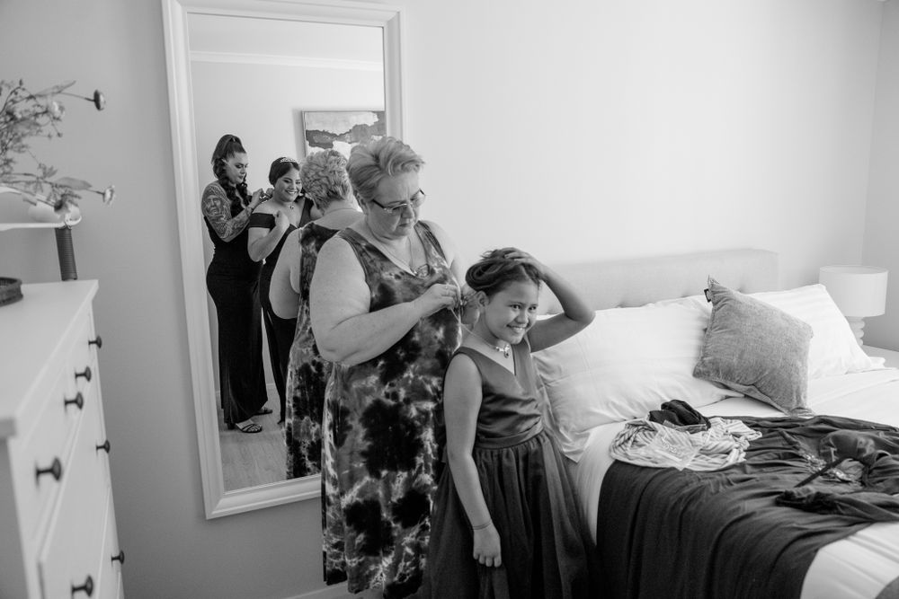 Black and white photo of wedding preparation scene in bedroom.