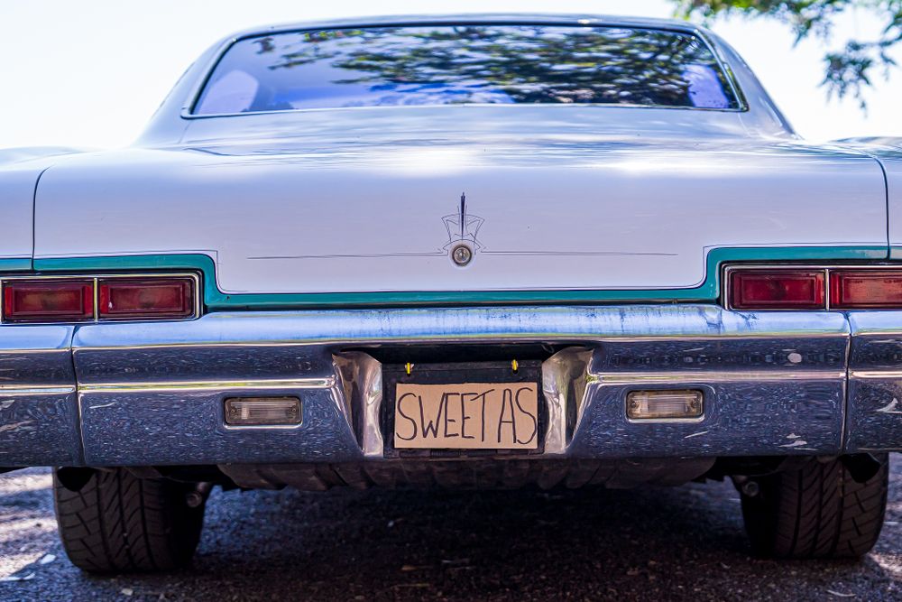 Rear view of vintage car with 'SWEETAS' license plate.