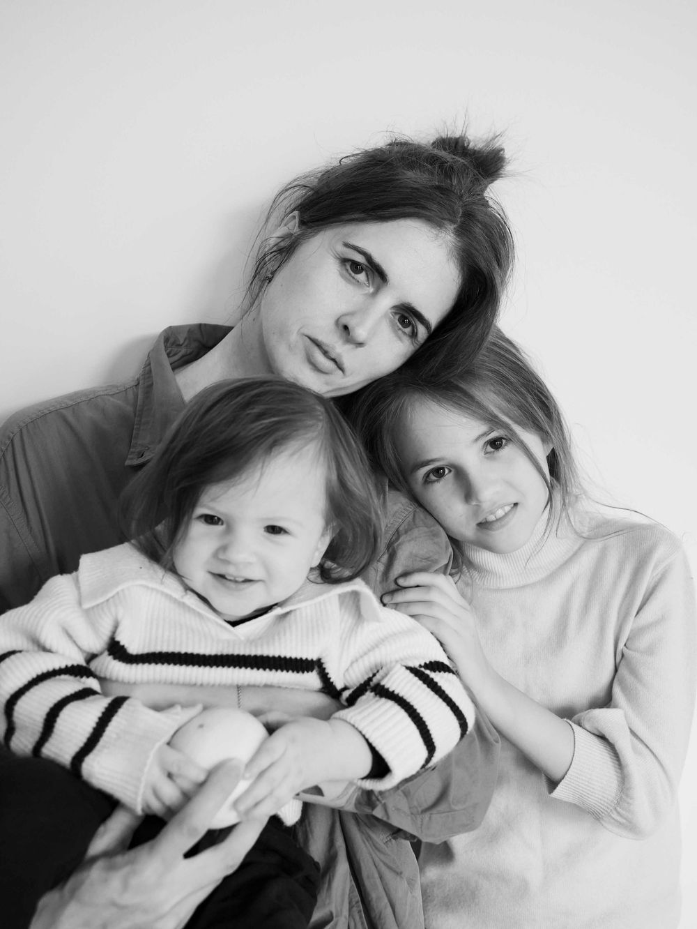 Mother and two daughters hug.