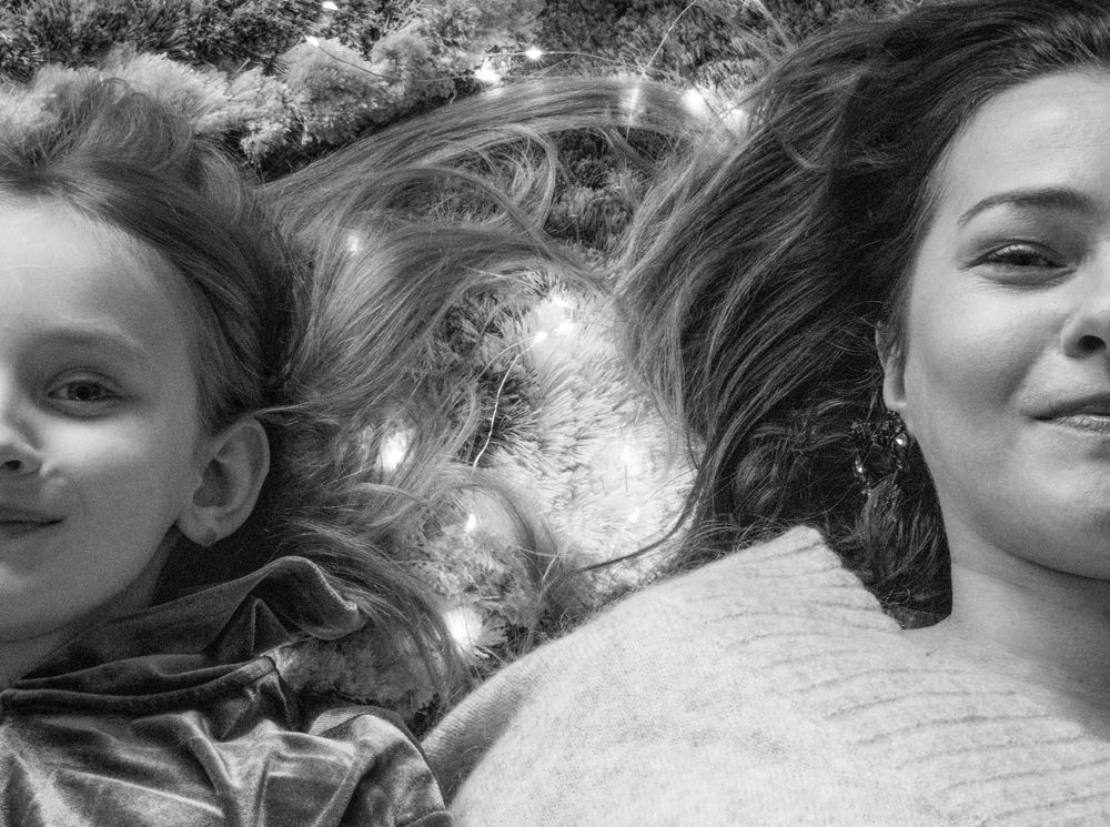 Mother and daughter lie on the carpet and enjoy the festive mood.