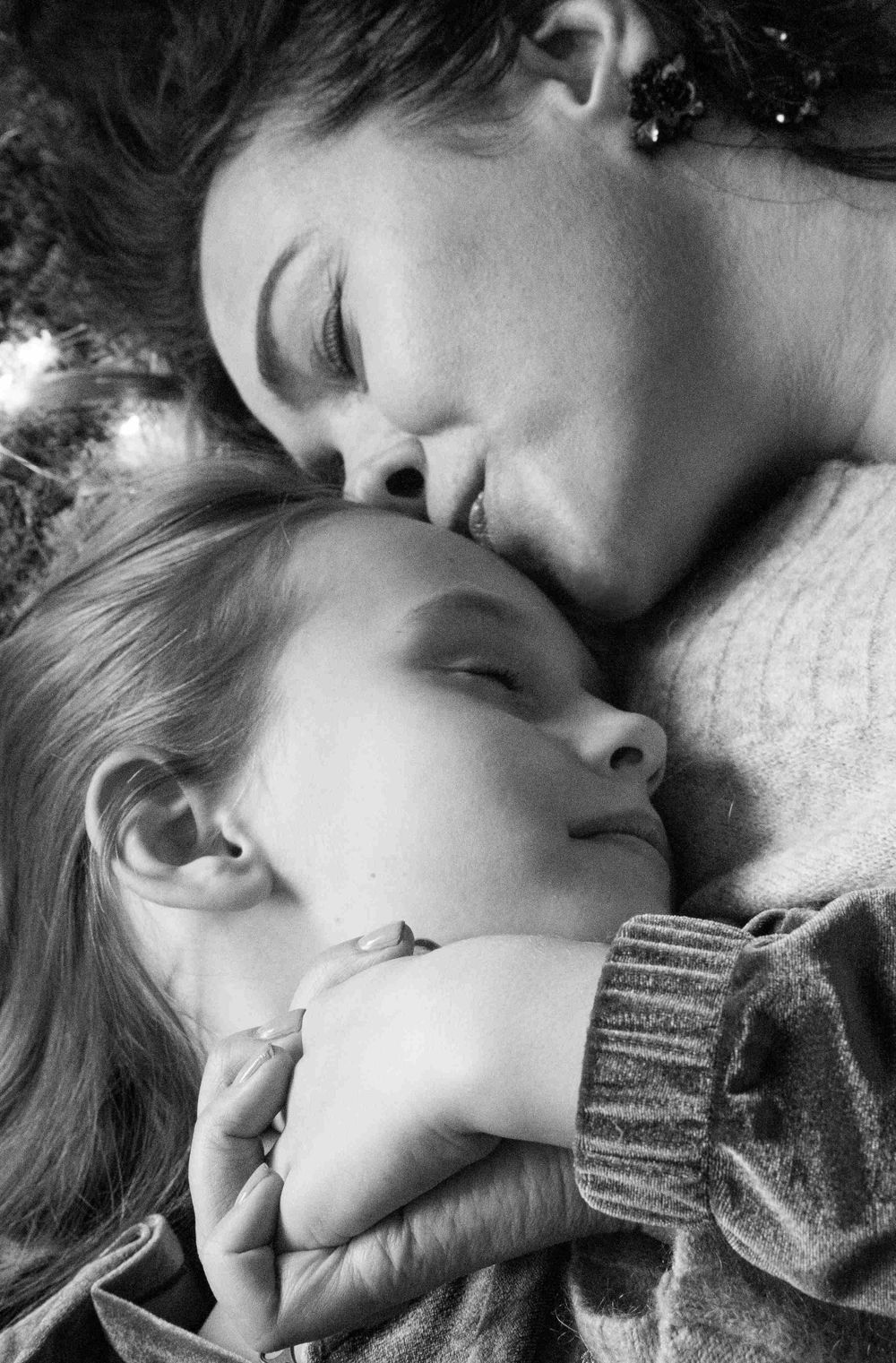Mother is kissing her daughter.