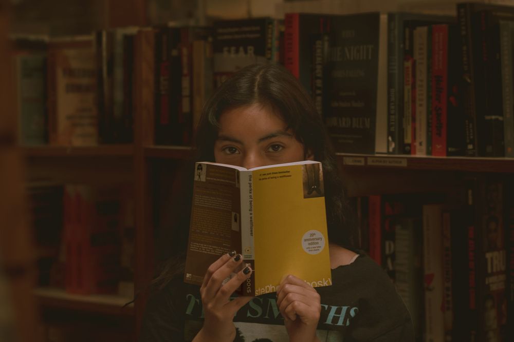 High school senior posing behind "The Perks Of Being A Wallflower" in Auntie's Bookstore Downtown Spokane Washington