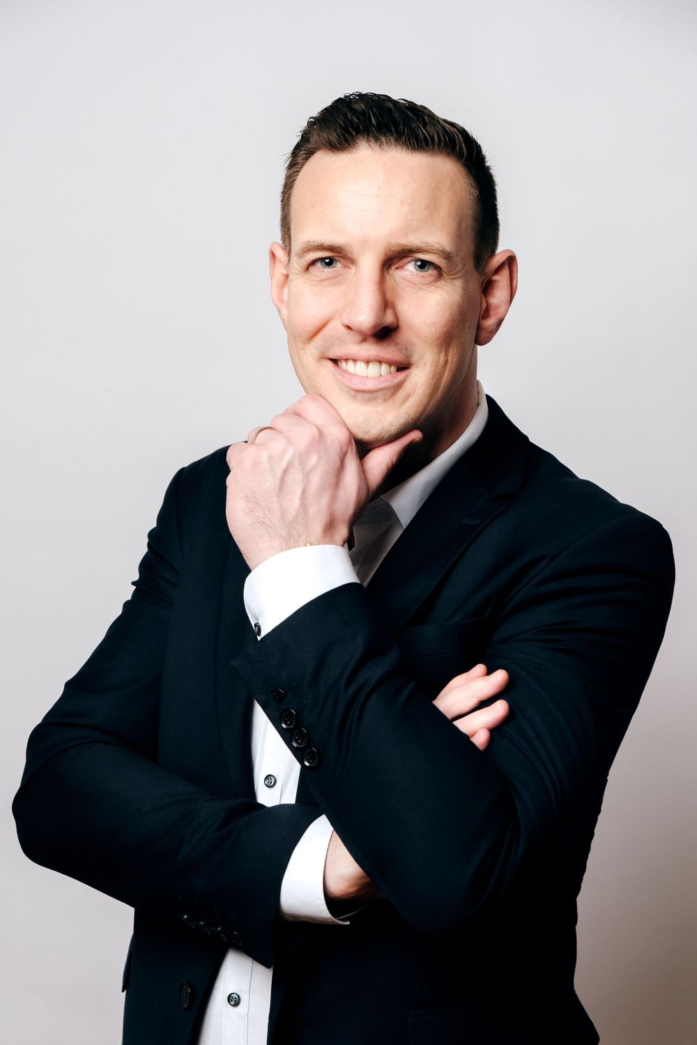Professional headshots of a person in formal black attire against light background showing friendly expressions.