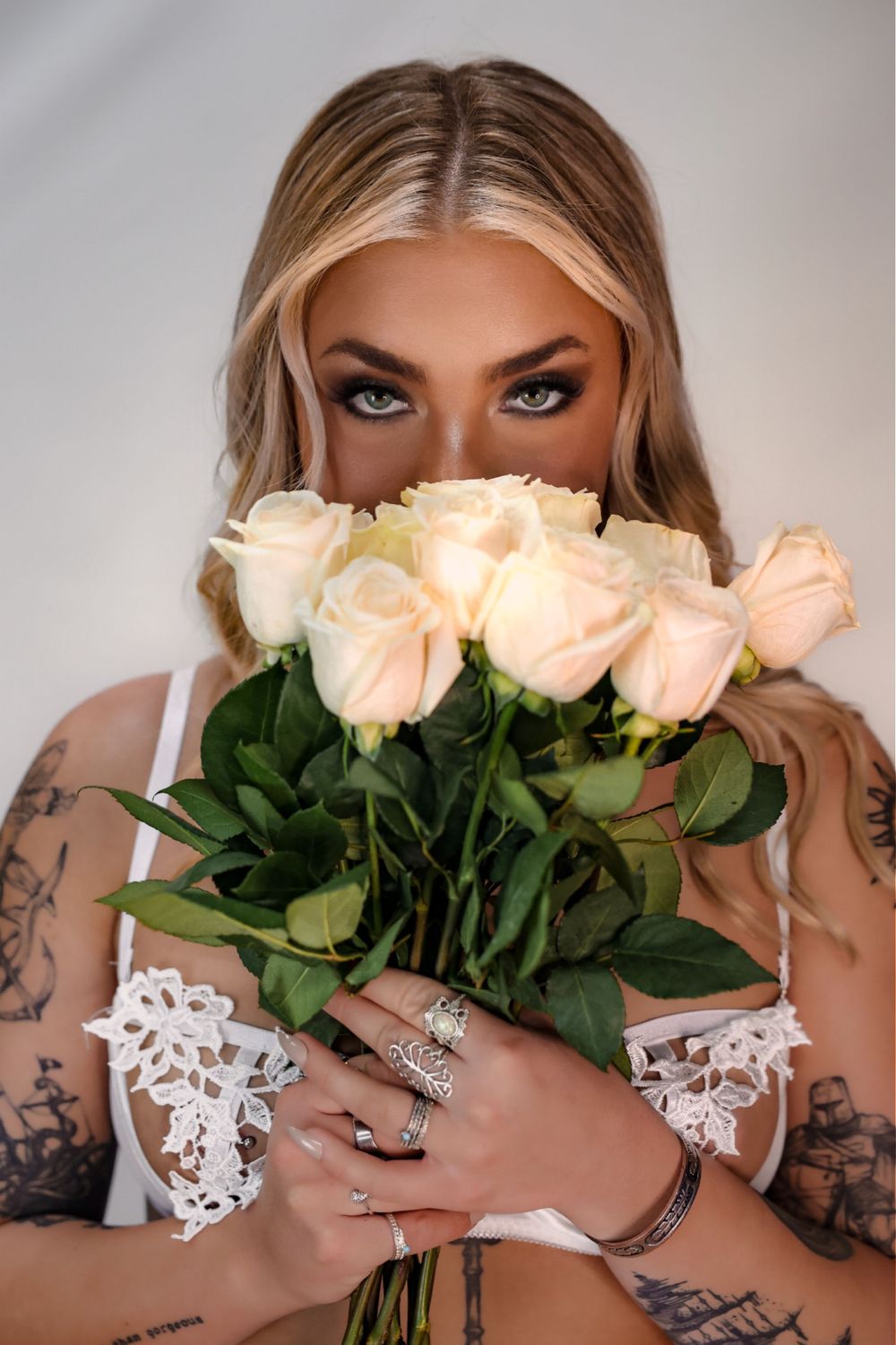 Elegant portrait with peach roses and white lace details against light background.