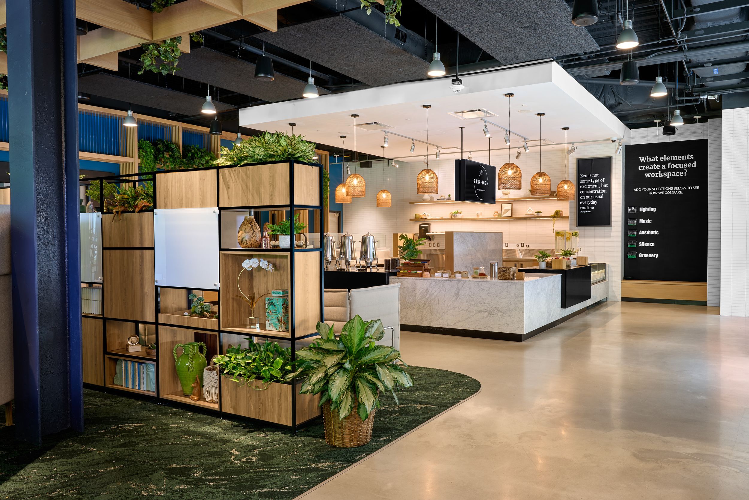 Modern office space with wooden dividers, indoor plants, and minimalist cafe area.