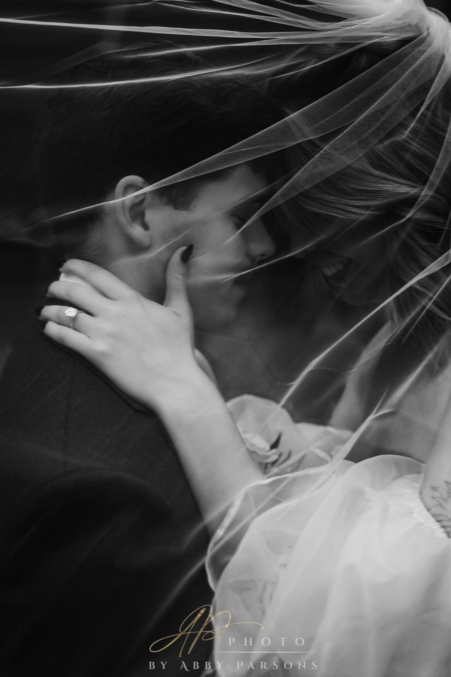 A ethereal black and white bridal portrait showing delicate veil details in soft lighting.