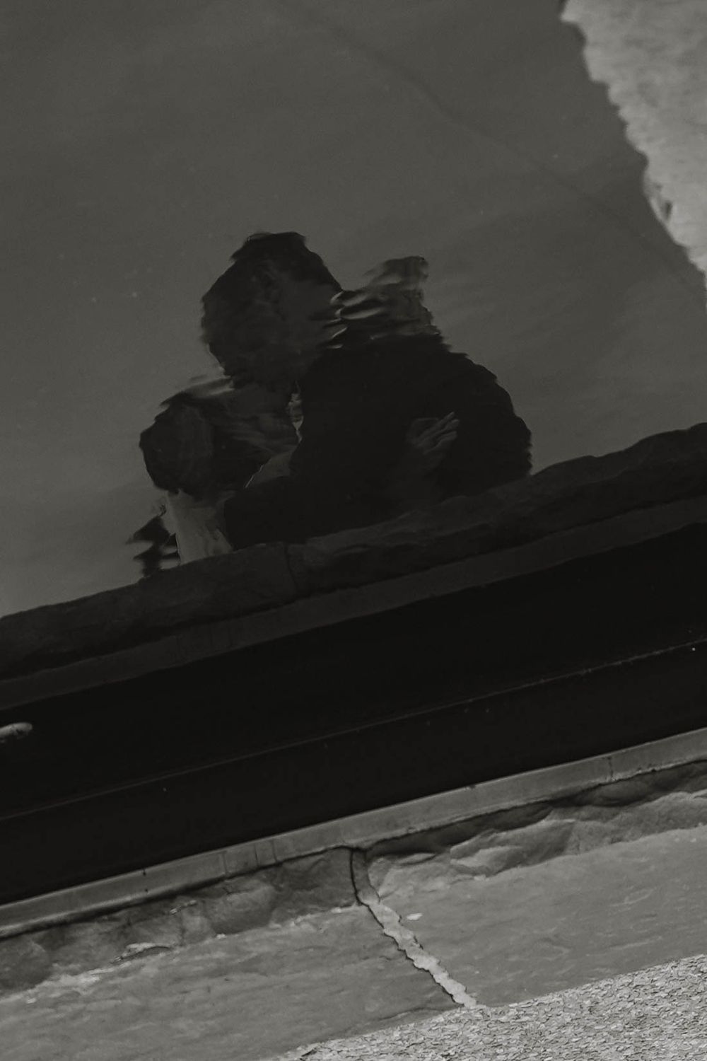 Artistic black and white architectural detail showing shadows and geometric shapes against a dark background.