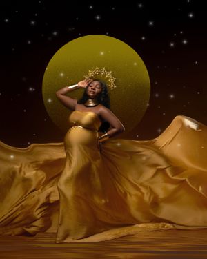 Artistic maternity portrait with flowing gold dress against starry night backdrop.
