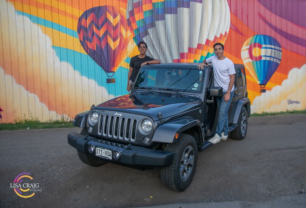 Black Jeep Wrangler parked in front of vibrant hot air balloon mural wall art.  Senior Portrait Photographer | Denver, Broomfield, Boulder |