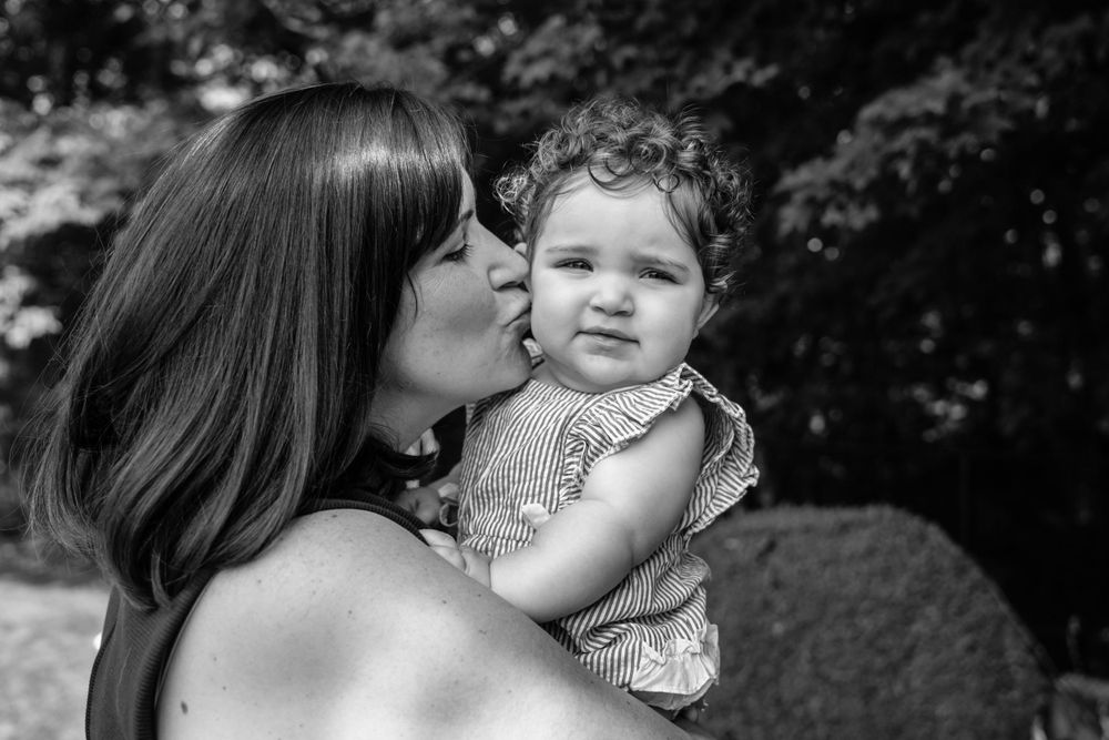 Black and white portrait capturing tender moment outdoors.