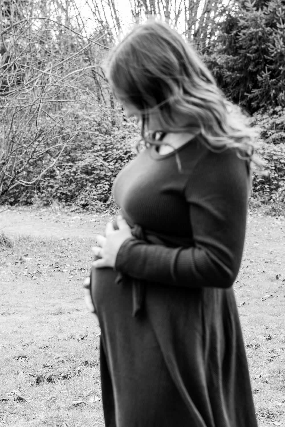 A sequence of black and white photos showing two people embracing outdoors in a natural setting.