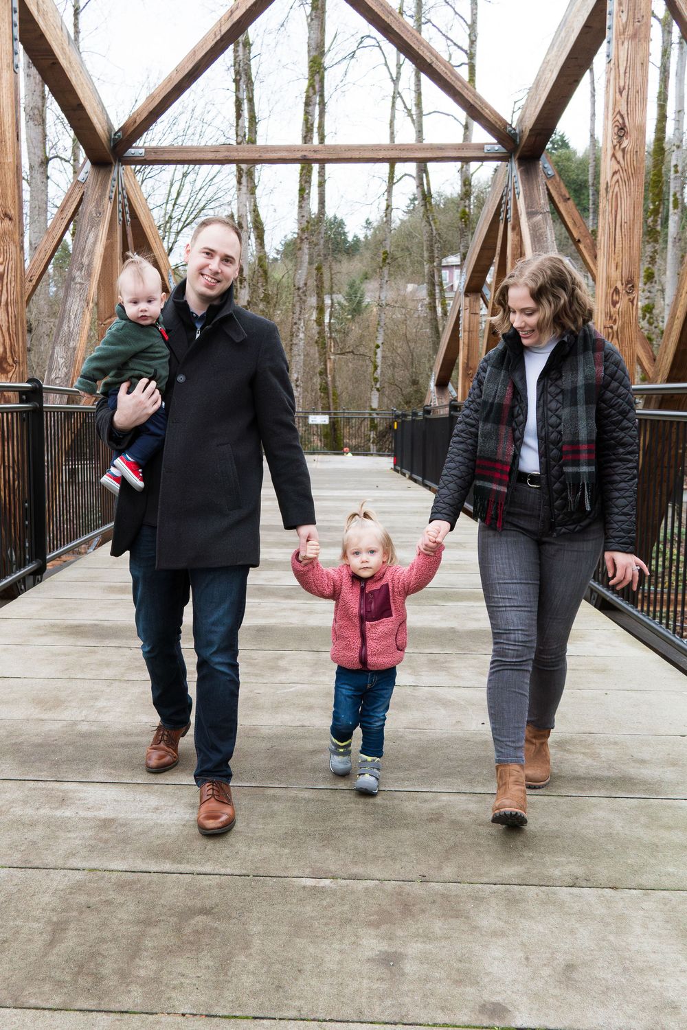 A family walks together along a wooden bridge path, showing four progressive shots of their journey.