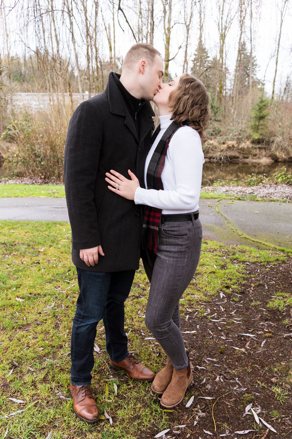 A romantic outdoor moment shared between a couple in casual winter attire.